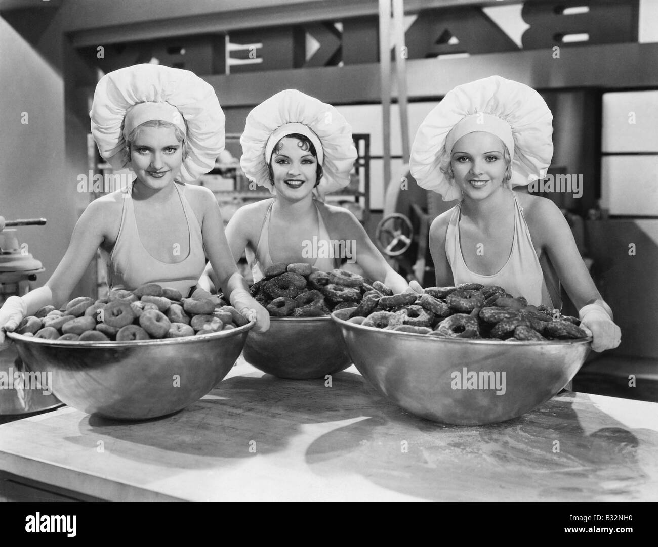 Drei Frauen mit riesigen Schalen mit donuts Stockfoto