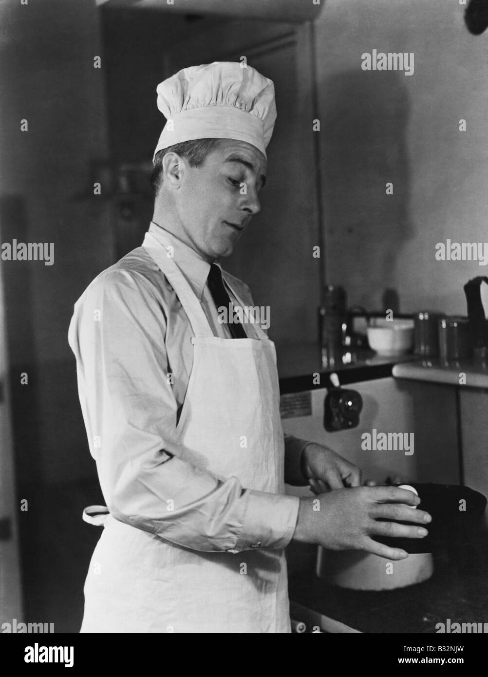 Mann in Koch Hut und Schürze Kochen Stockfoto