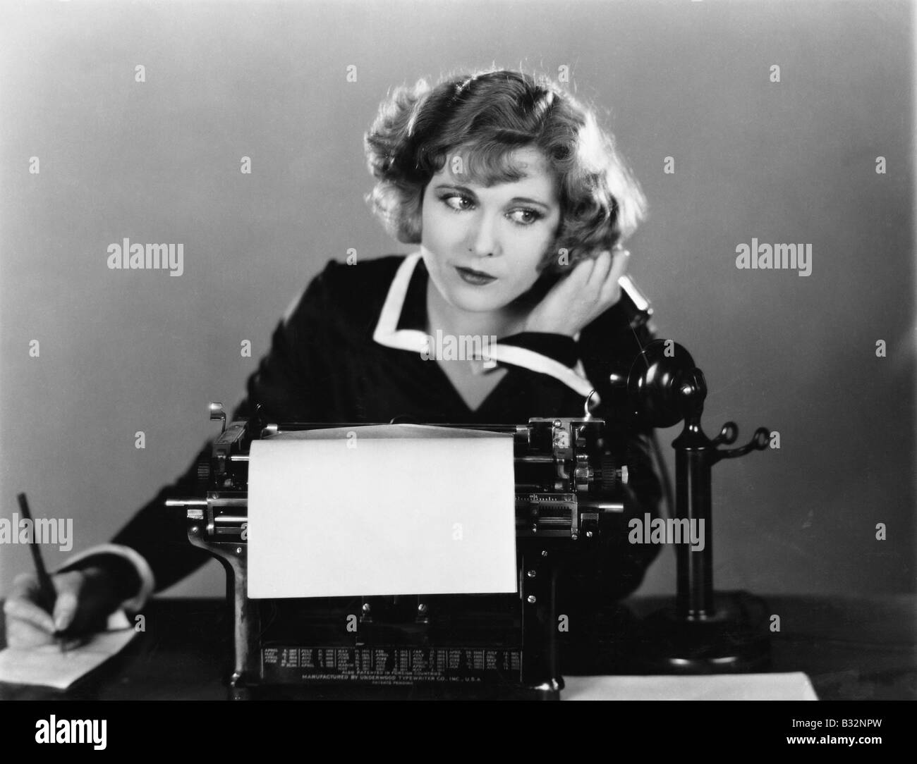 Frau am Schreibmaschine auf Telefon Stockfoto