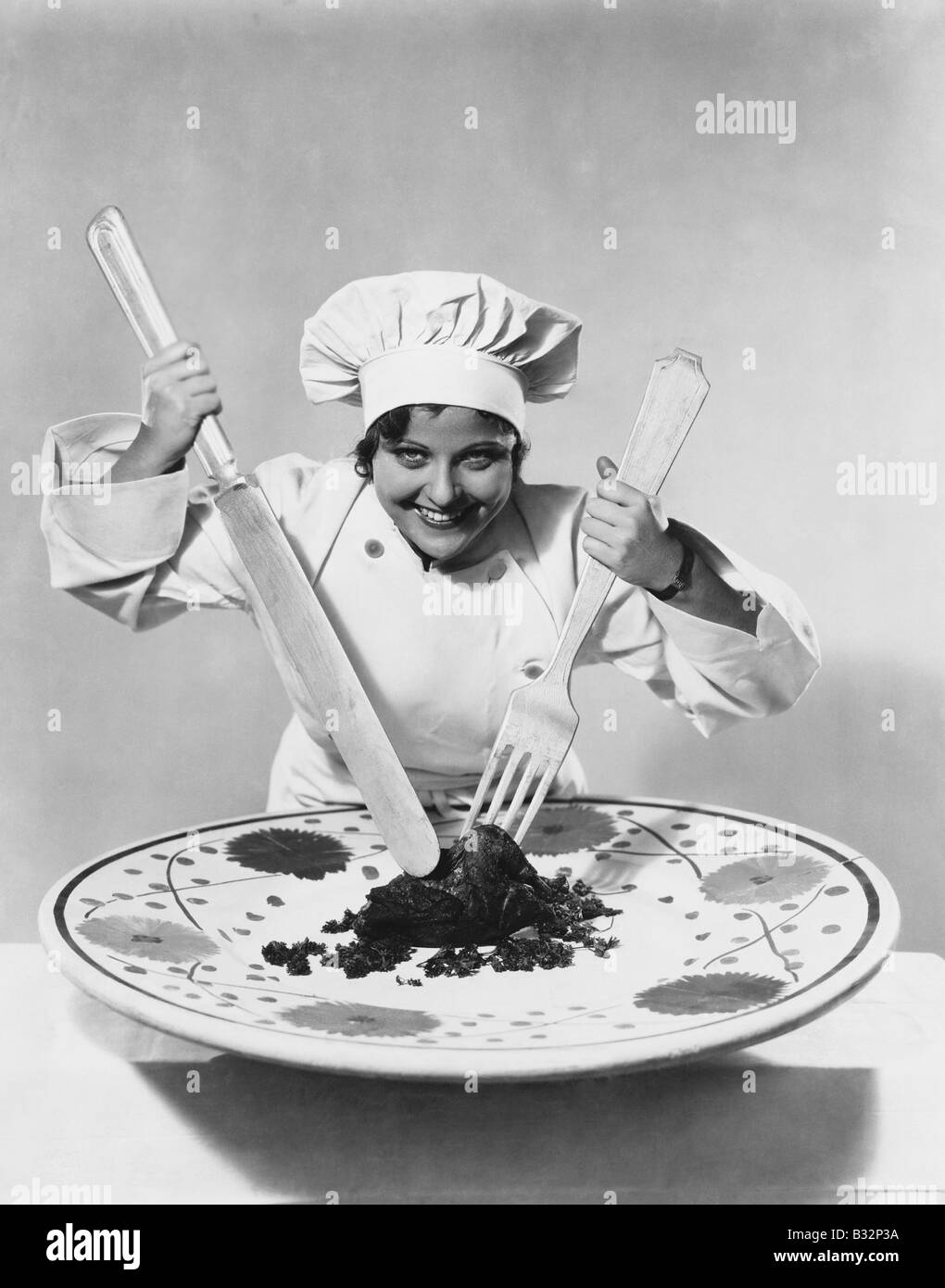 Kochen Sie mit Lebensmitteln auf übergroße Teller mit Oversize Utensilien Stockfoto