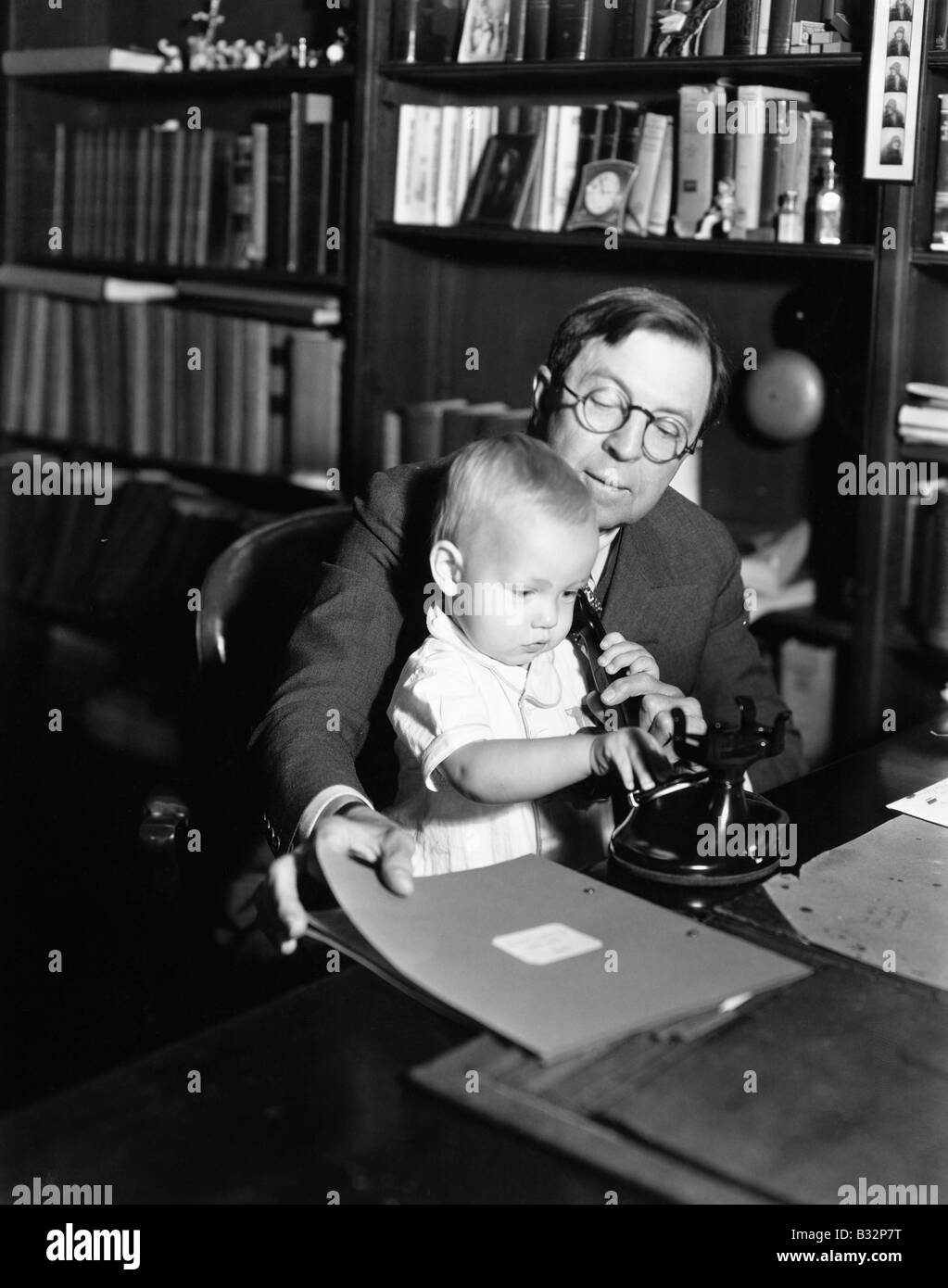 Vater helfen Baby Nutzung Telefon Stockfoto