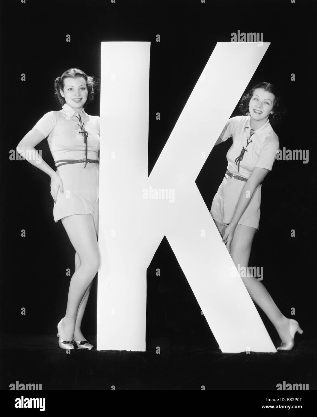 Frauen posieren mit riesigen Buchstaben K Stockfoto