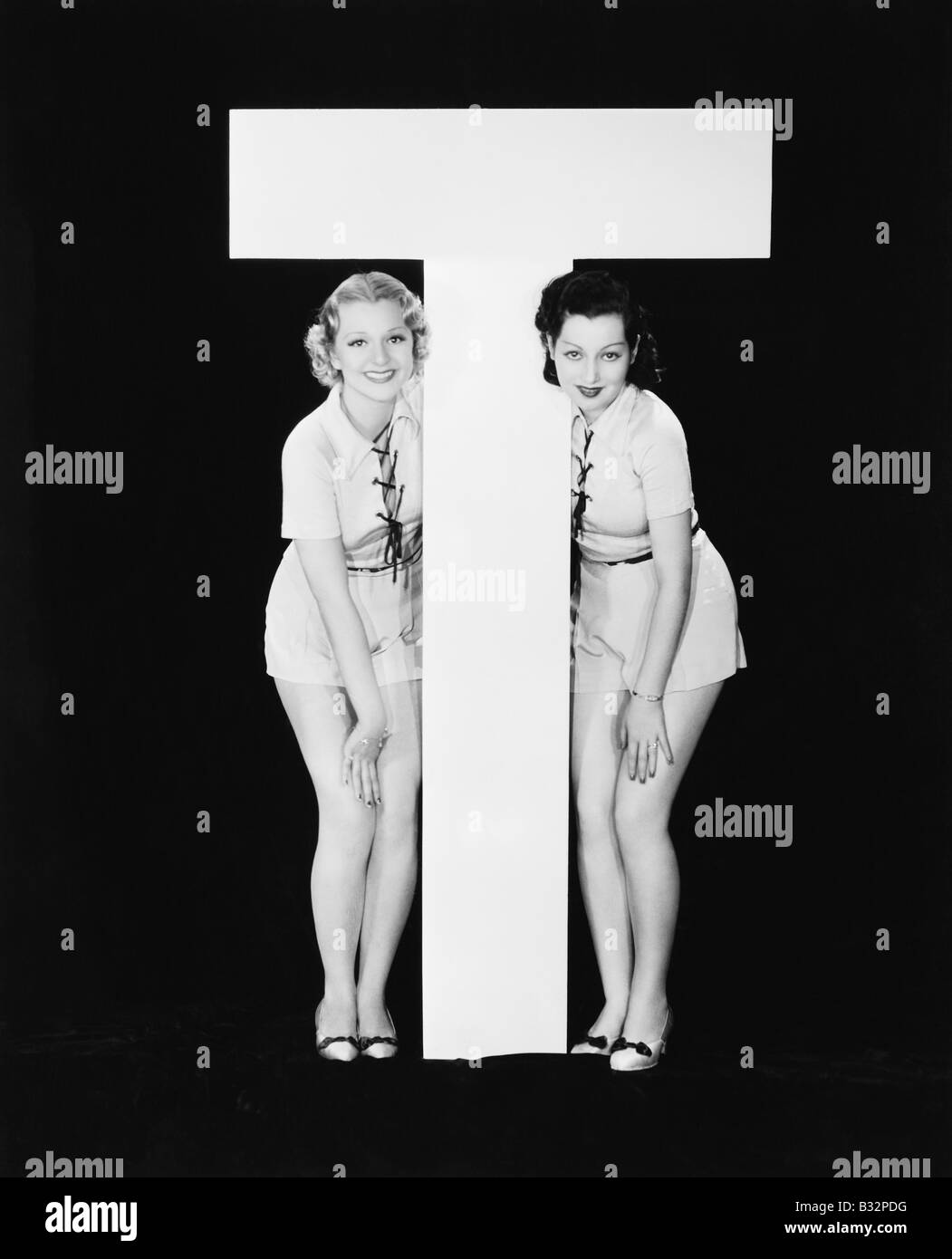 Frauen posieren mit riesigen Buchstaben T Stockfoto