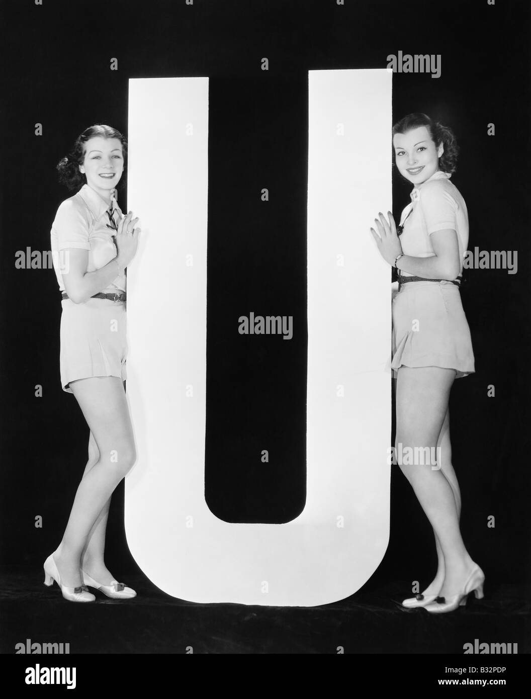 Frauen posieren mit riesigen Buchstaben U Stockfoto