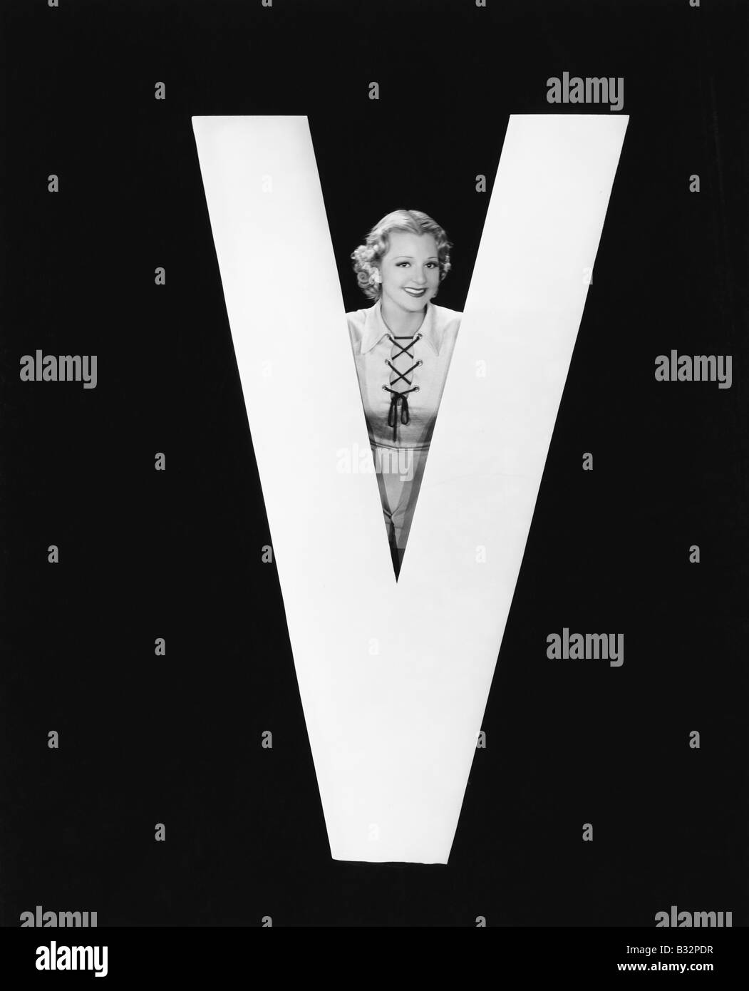 Frau posiert mit riesigen Buchstaben V Stockfoto
