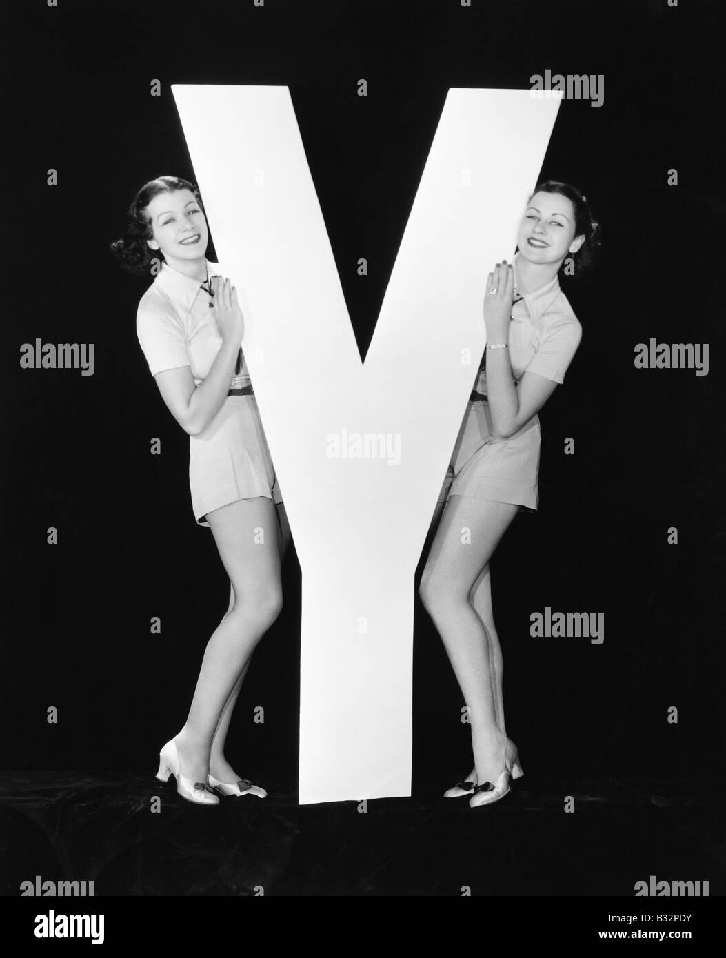 Frauen posieren mit riesigen Buchstaben Y Stockfoto
