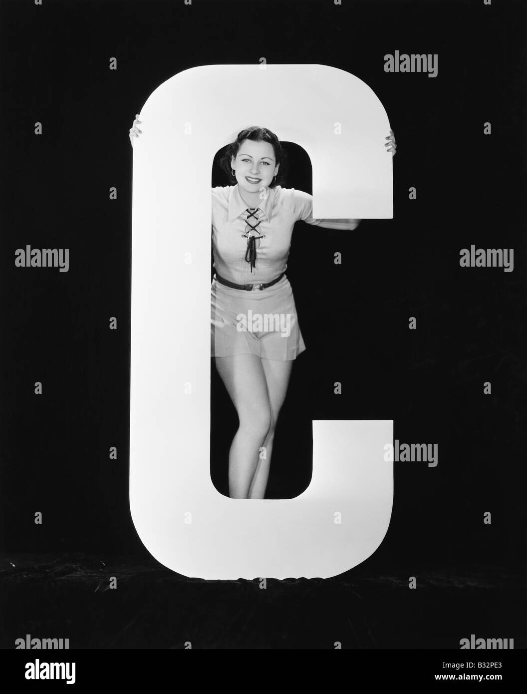 Frau posiert mit riesigen Buchstaben C Stockfoto