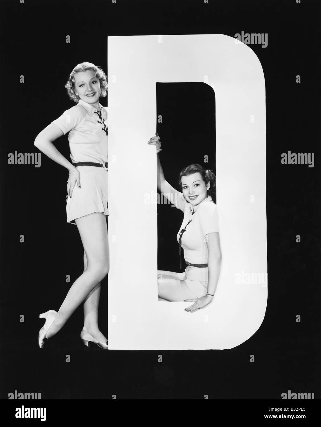 Frauen posieren mit riesigen Buchstaben D Stockfoto