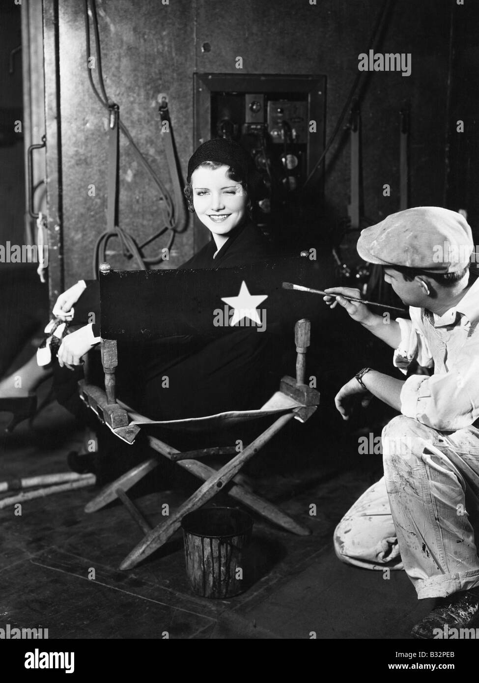 Frau, die Namen auf Rückseite Regiestuhl gemalt Stockfoto