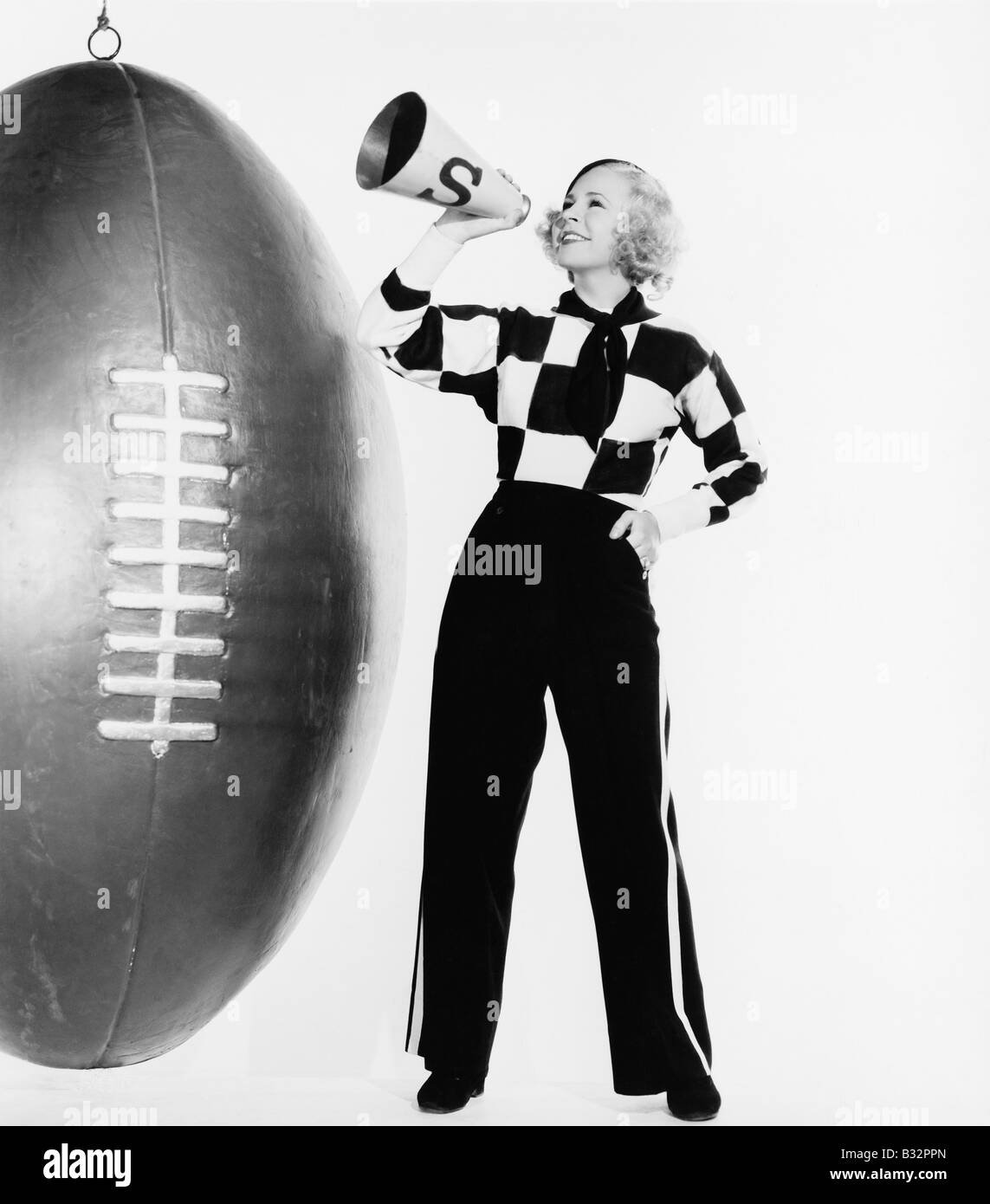 Frau mit Megaphon und riesigen Fußball Stockfoto