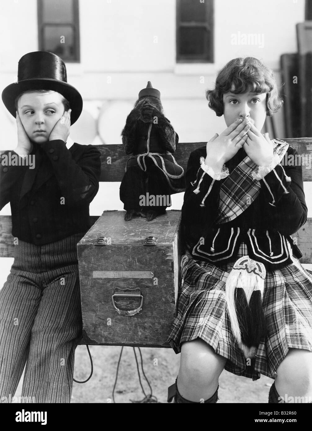 Zwei Kinder und ein Affe spielen hören, nichts Böses, nichts Böses sehen, nichts Böses sprechen Stockfoto