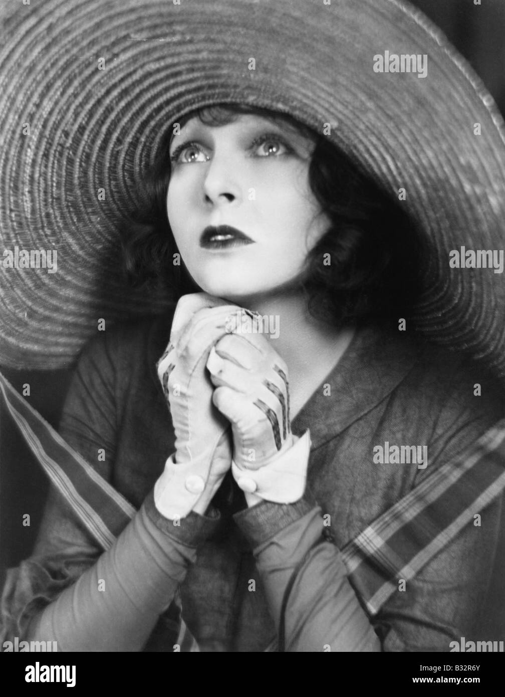 Junge Frau in einen großen Hut zu beten Stockfoto