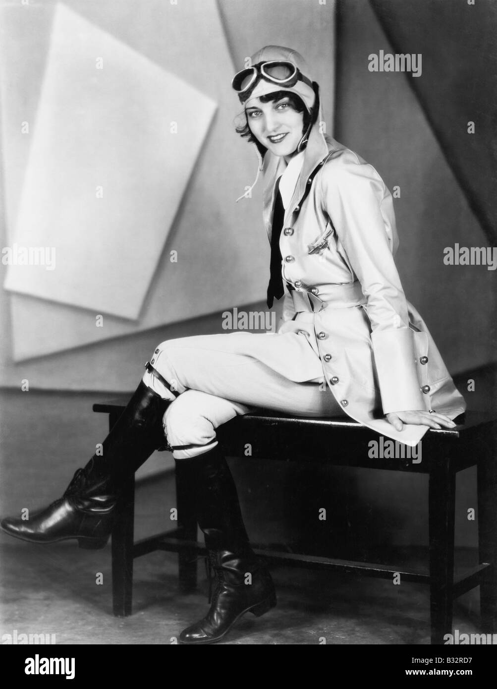 Frau sitzt auf einer Bank in einem Piloten uniform Stockfoto