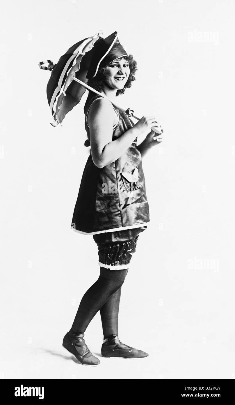 Frau posiert in einem Kleid mit einem Sonnenschirm Stockfoto