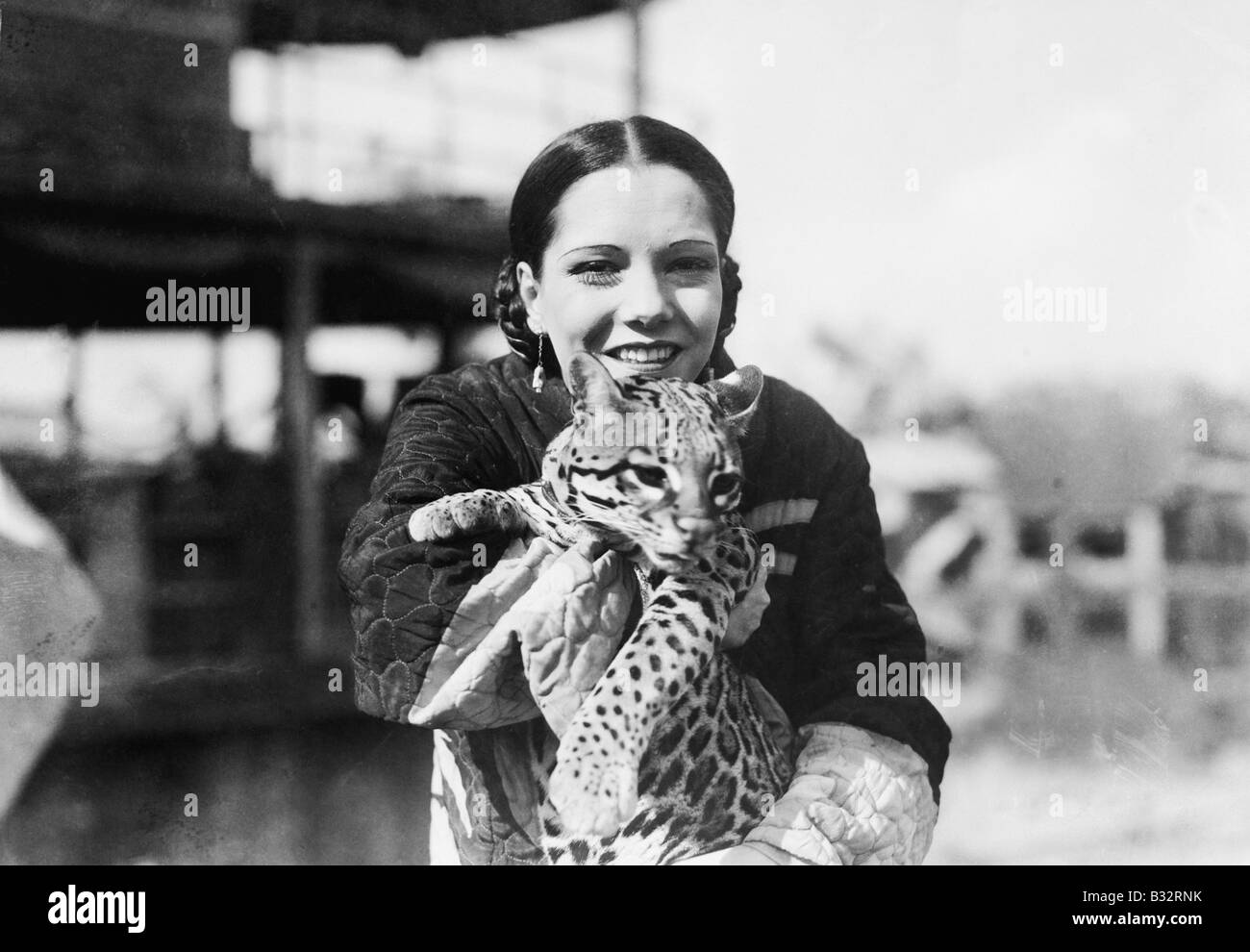 Porträt einer jungen Frau trägt eine Gepard Cub und lächelnd Stockfoto