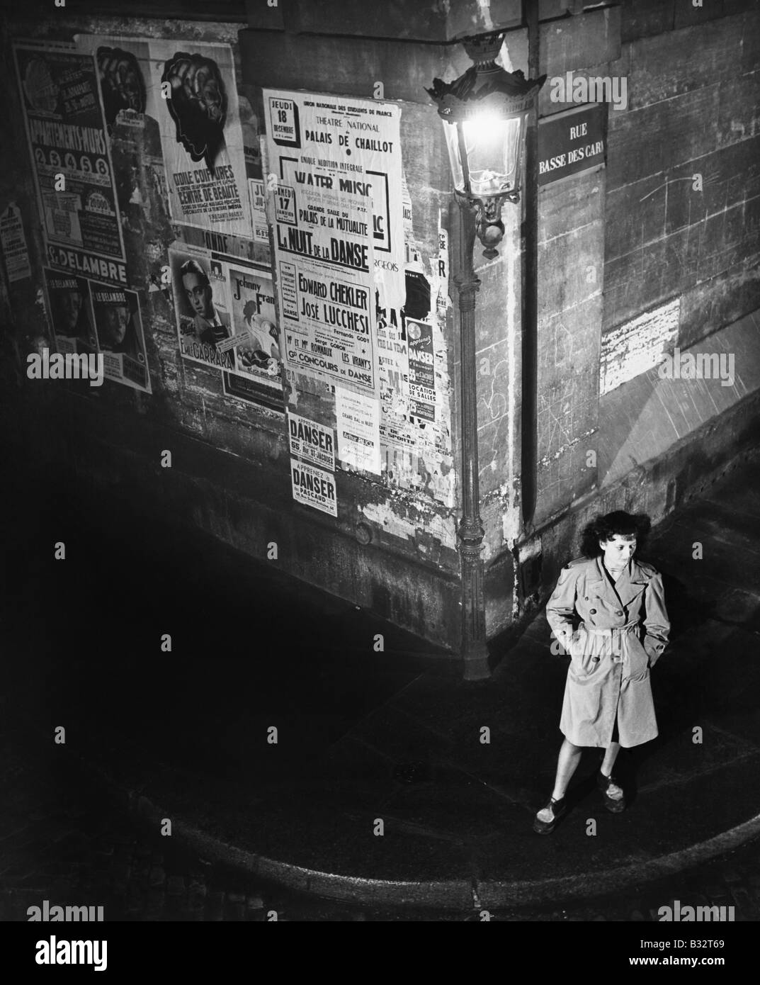 Erhöhte Ansicht einer jungen Frau, die neben einer Laterne auf einer dunklen Straßenecke warten Stockfoto