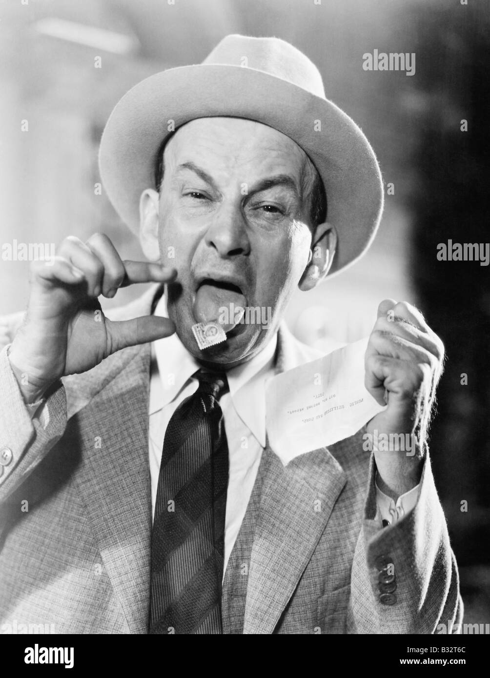 Mann mit einer Briefmarke auf seiner Zunge stecken Stockfoto