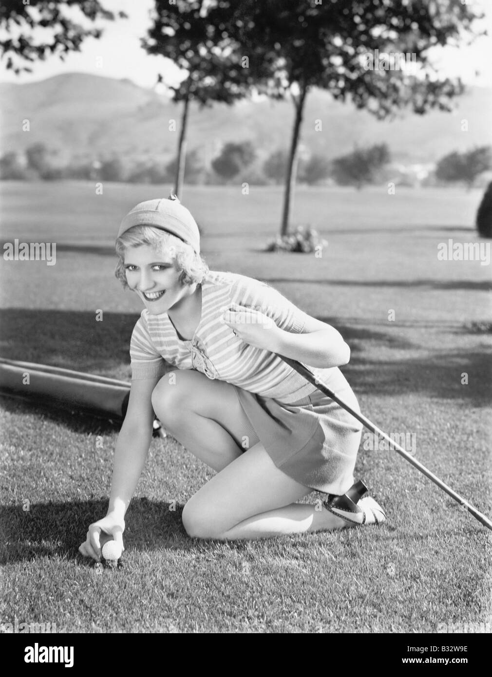 Junge Frau auf einem Golfplatz Platzierung einen Golfball Stockfoto