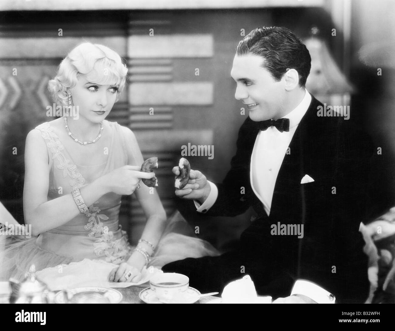 Paar, ein Spiel des Teilens eines Donut Stockfoto