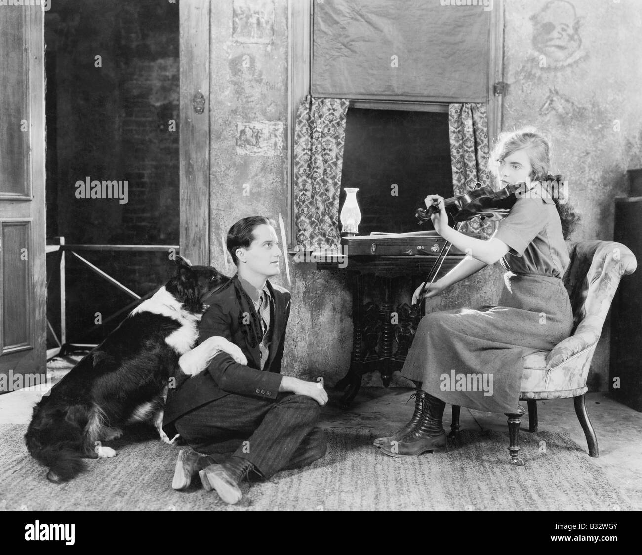 Frau spielt die Violine für ihren Freund und Hund Stockfoto