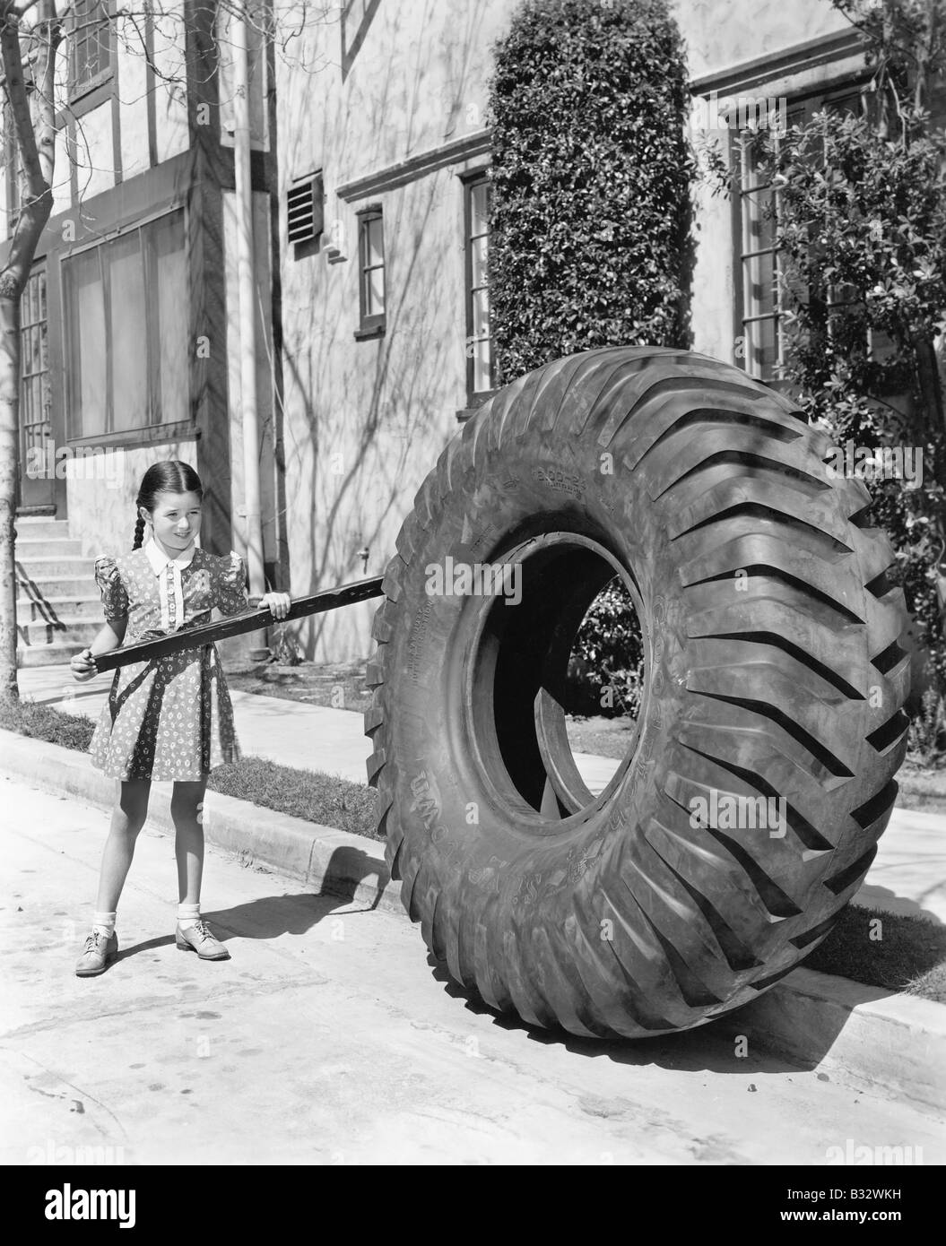 Mädchen spielen mit einem riesigen Reifen und stick Stockfoto