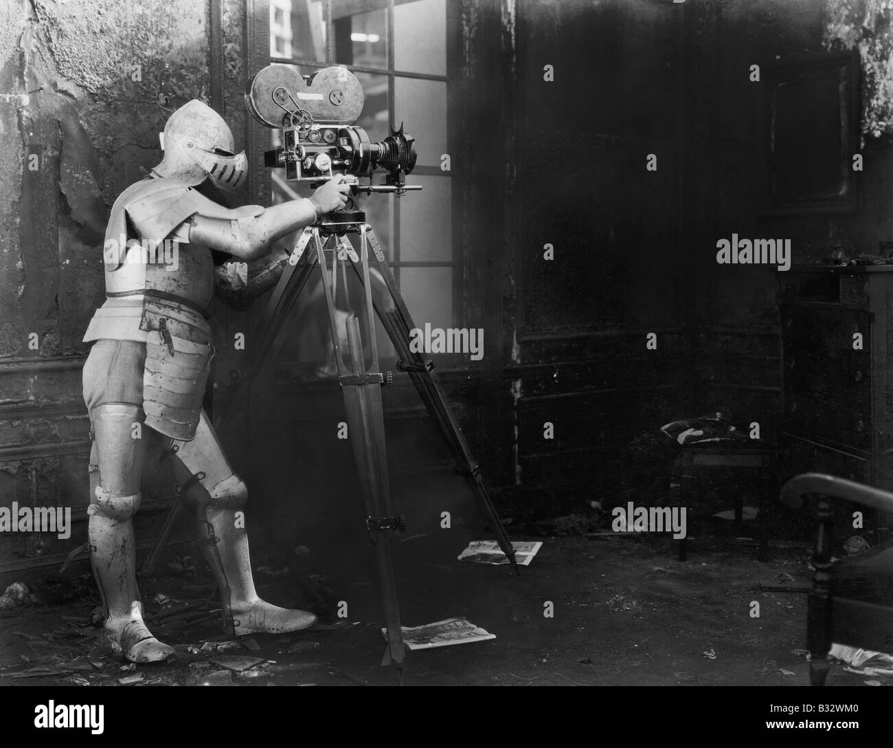 Ritter im Kino, ein Mann in einen gepanzerten Anzug verwendet eine Filmkamera Stockfoto