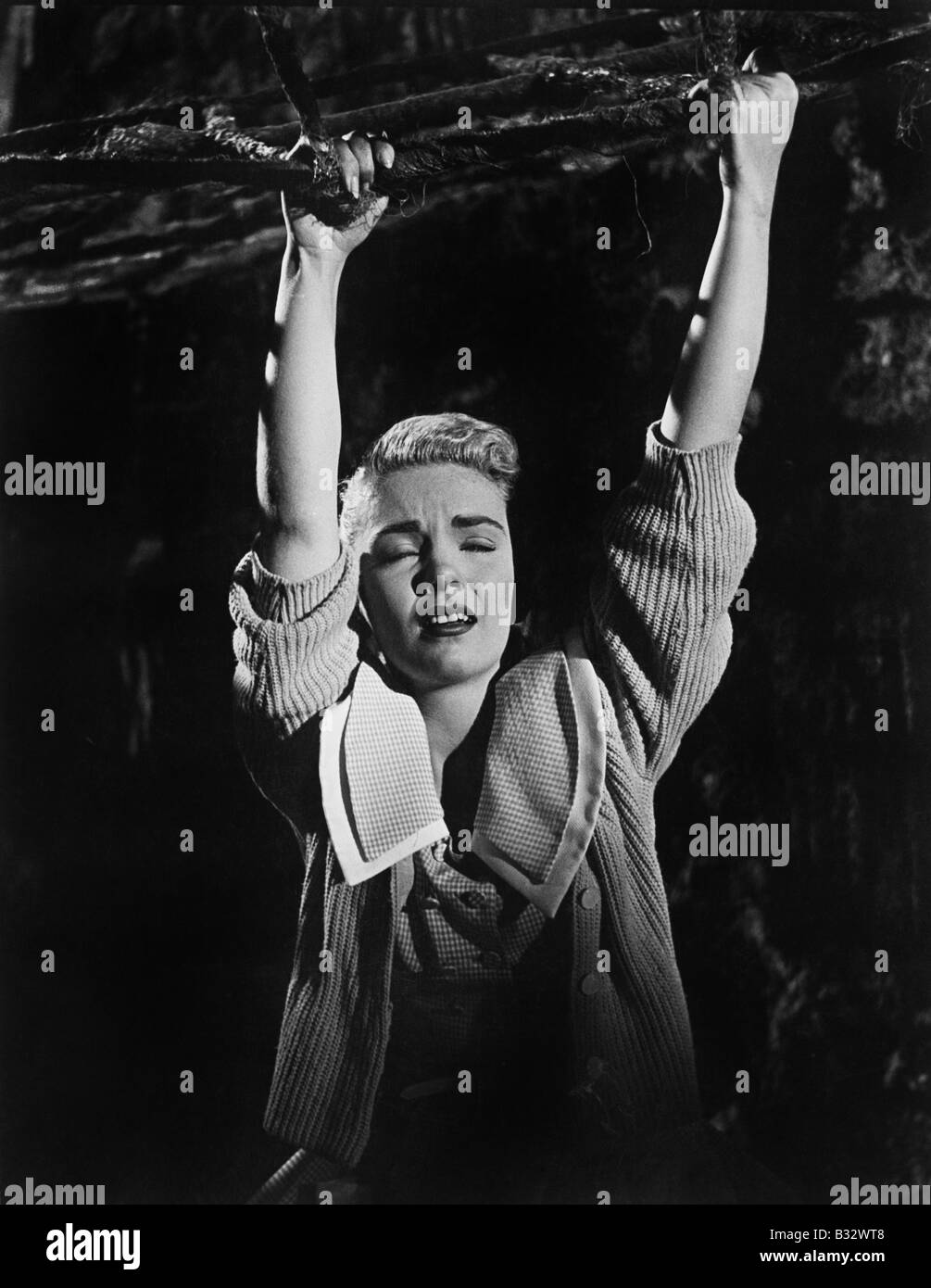 Junge Frau an einem Ast hängen Stockfoto