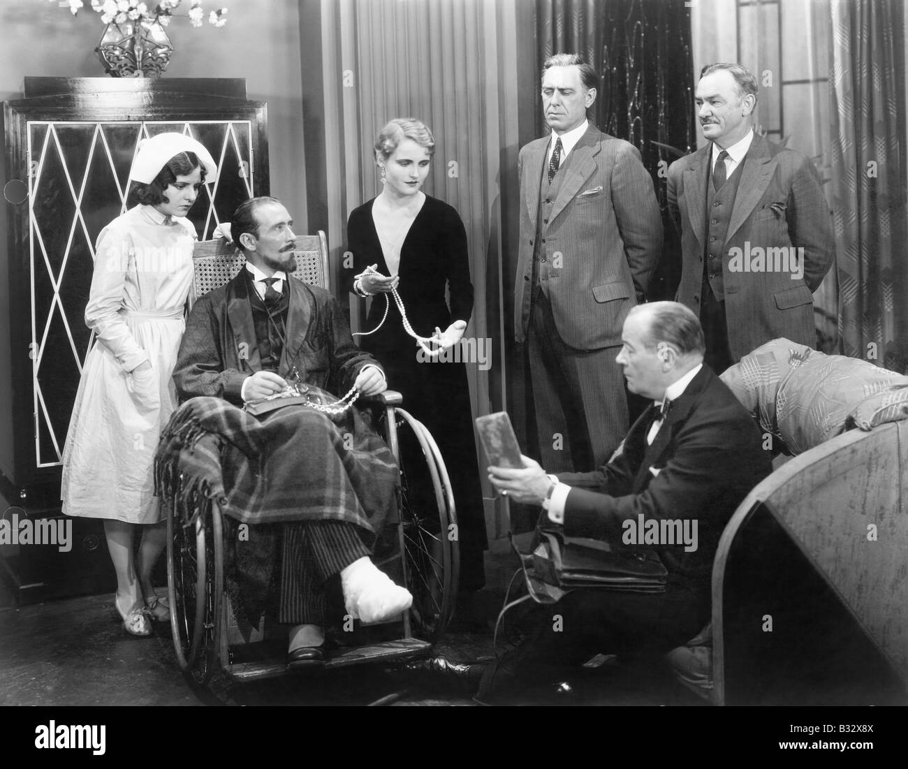 Mann im Rollstuhl mit einem gebrochenen Fuß und eine Gruppe von Menschen Stockfoto