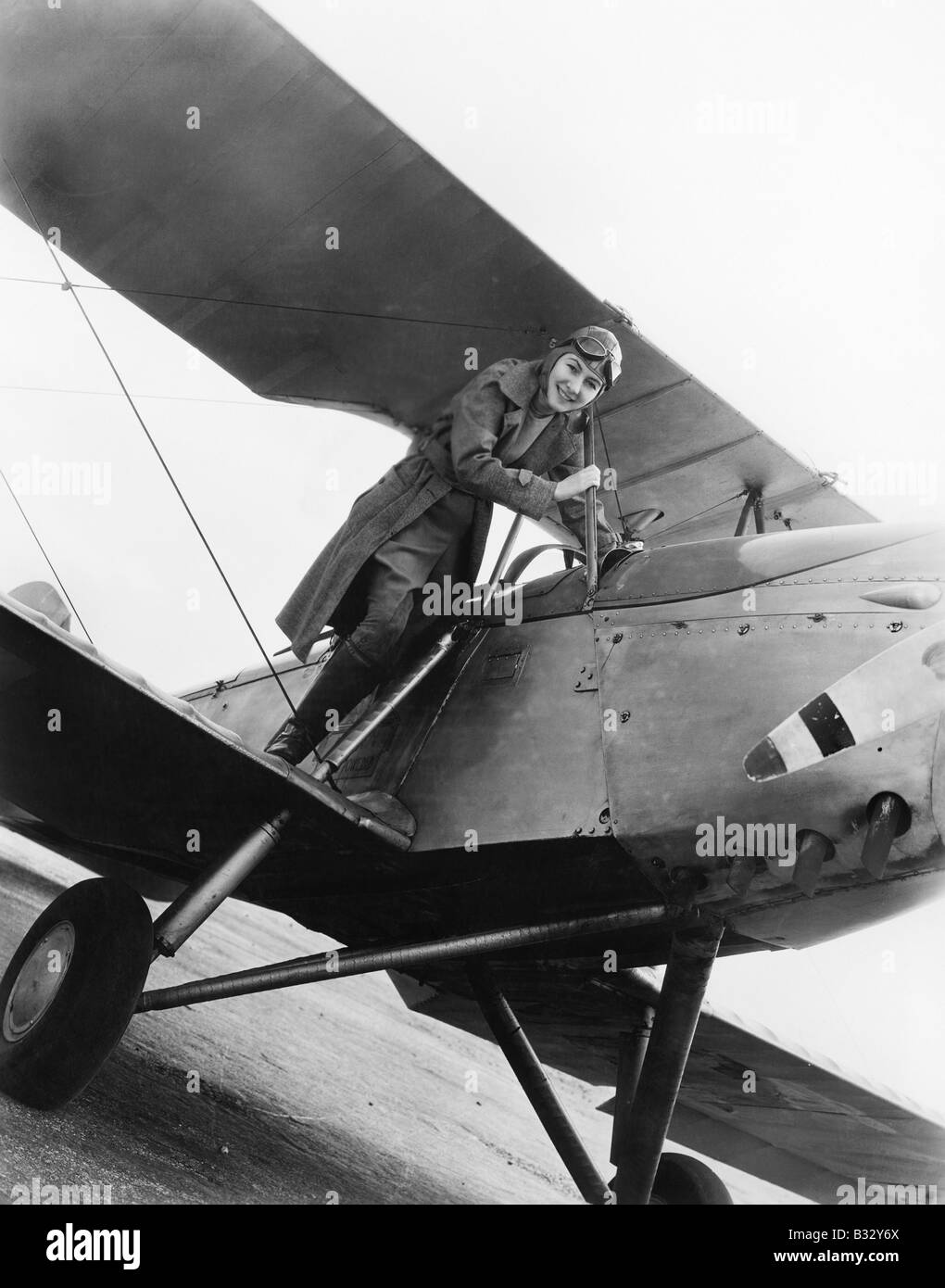 Junge Frau auf dem Flügel eines Flugzeuges Stockfoto