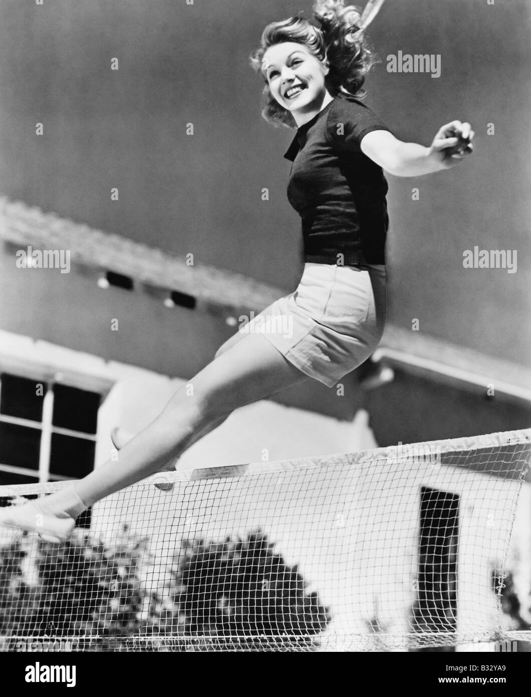 Frau, die über ein Tennis net springen Stockfoto