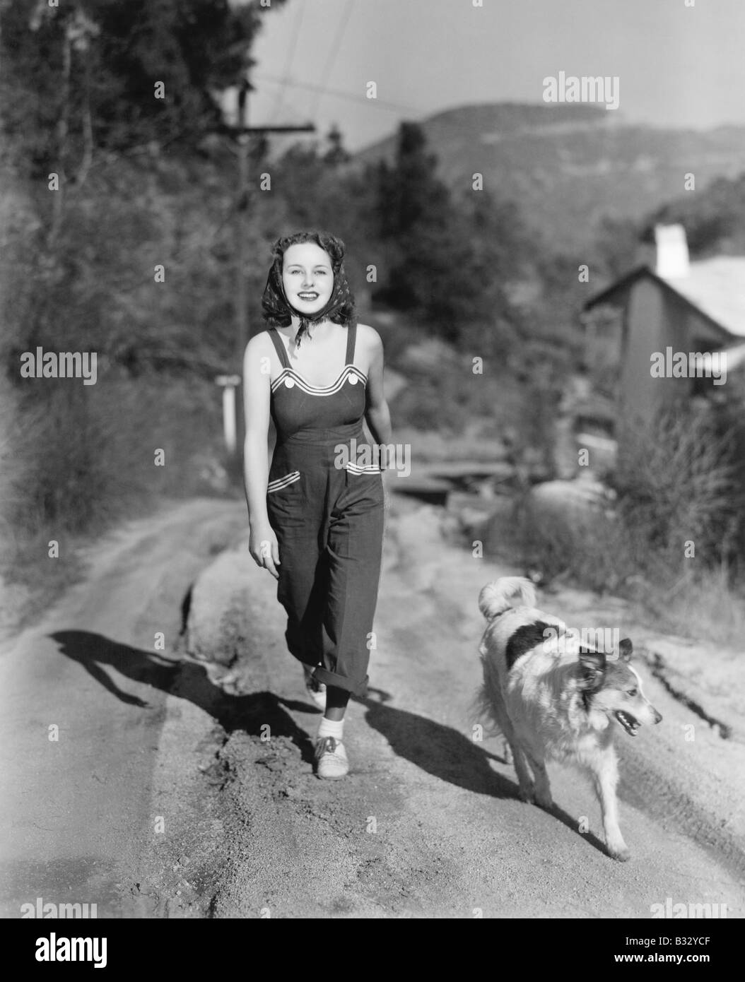 Frau zu Fuß ihr Collie auf einer Landstraße Stockfoto