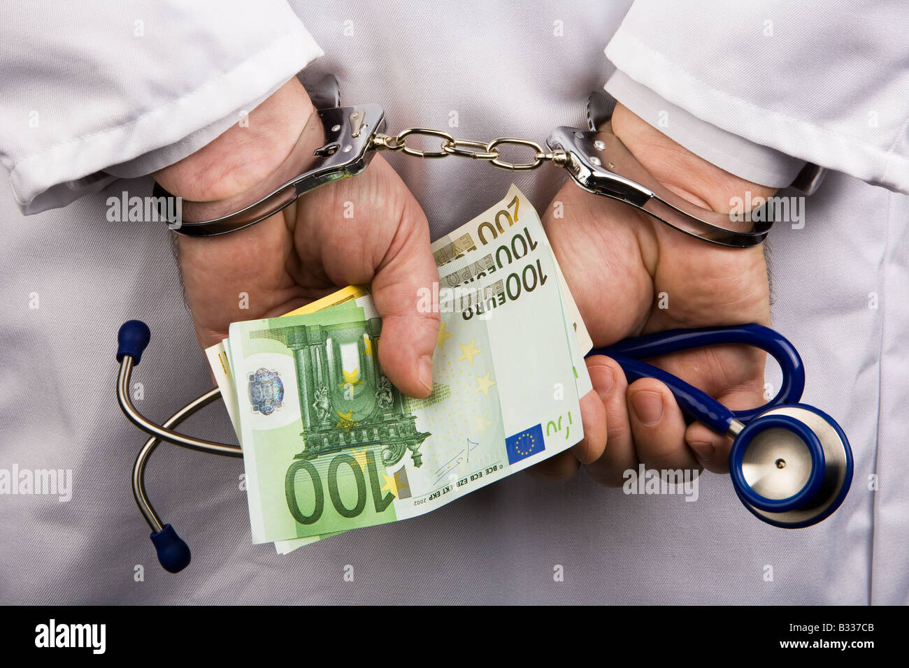 Arzt mit Banknoten und Handschellen Stockfoto