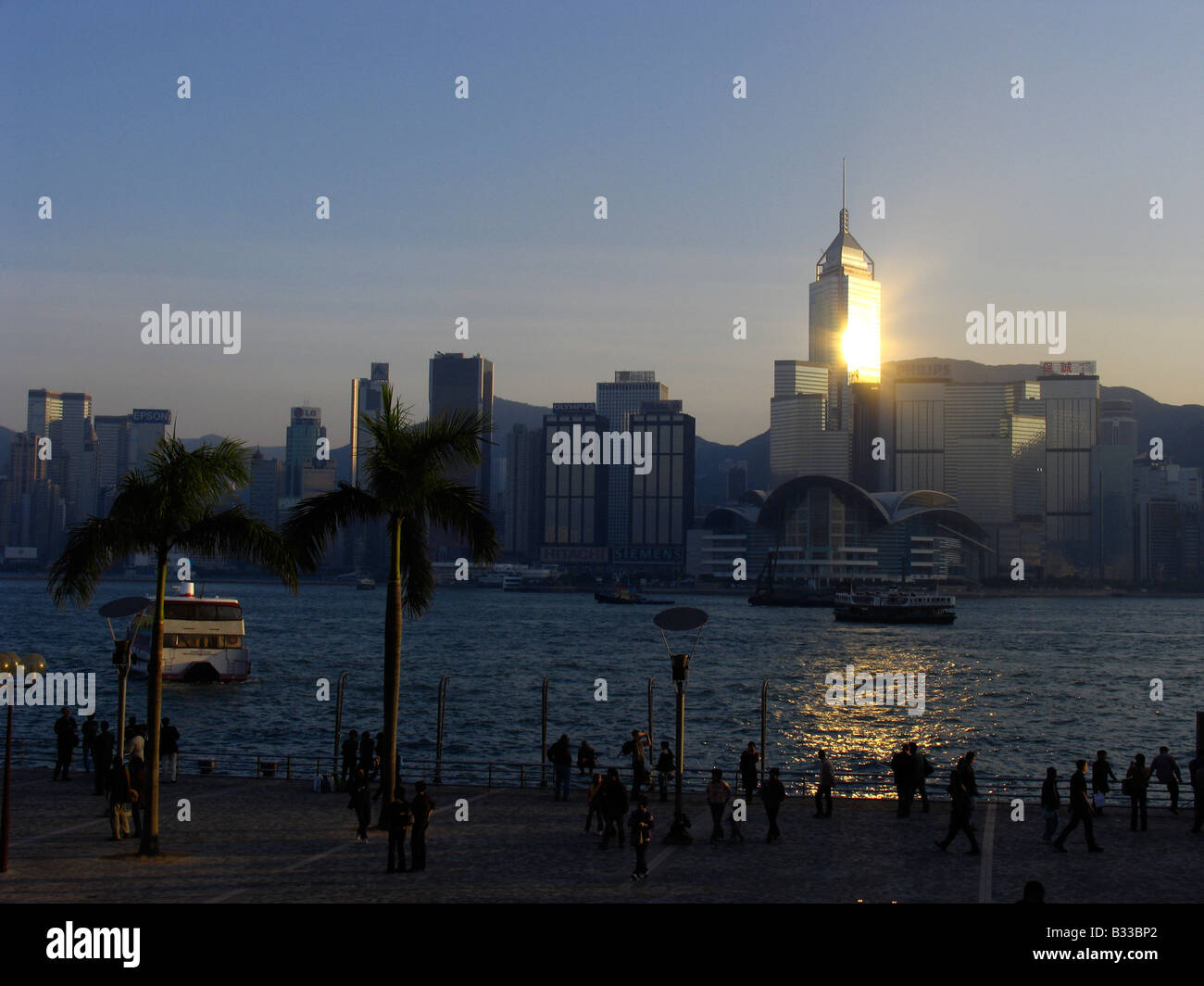 Zeigen Sie in der Dämmerung von Kowloons öffentlichen Anlegestelle an der Central District mit dem Convention and Exhibition Centre, Hongkong, China an Stockfoto