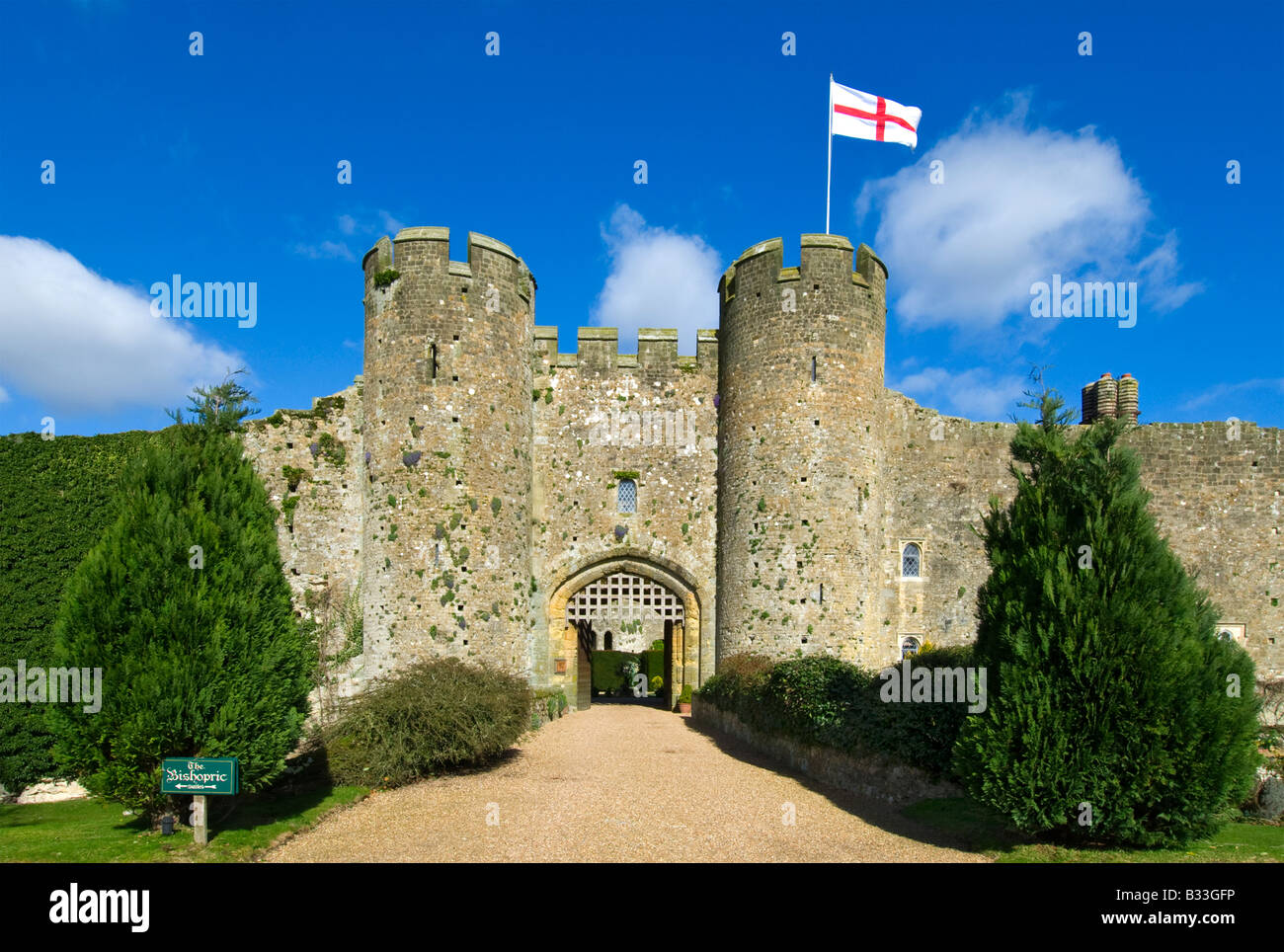 Amberley Castle Eingangstor im Frühjahr, fliegende England Flagge von Saint George, West Sussex England Großbritannien Stockfoto