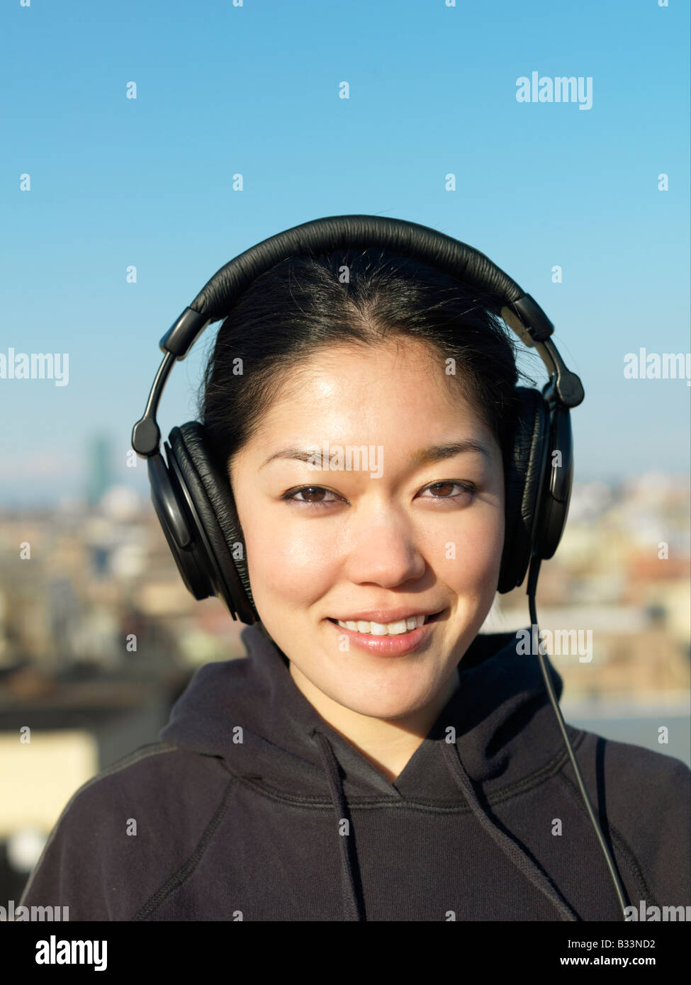 Ein Porträt einer jungen asiatischen Frau tragen Kopfhörer und Musik hören. Stockfoto