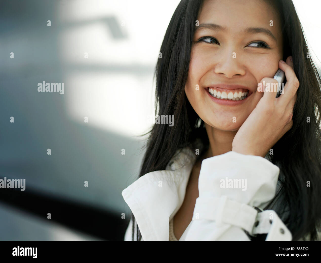 Eine junge chinesische Geschäftsfrau mit ihrem Handy PDA in der Stadt. Stockfoto