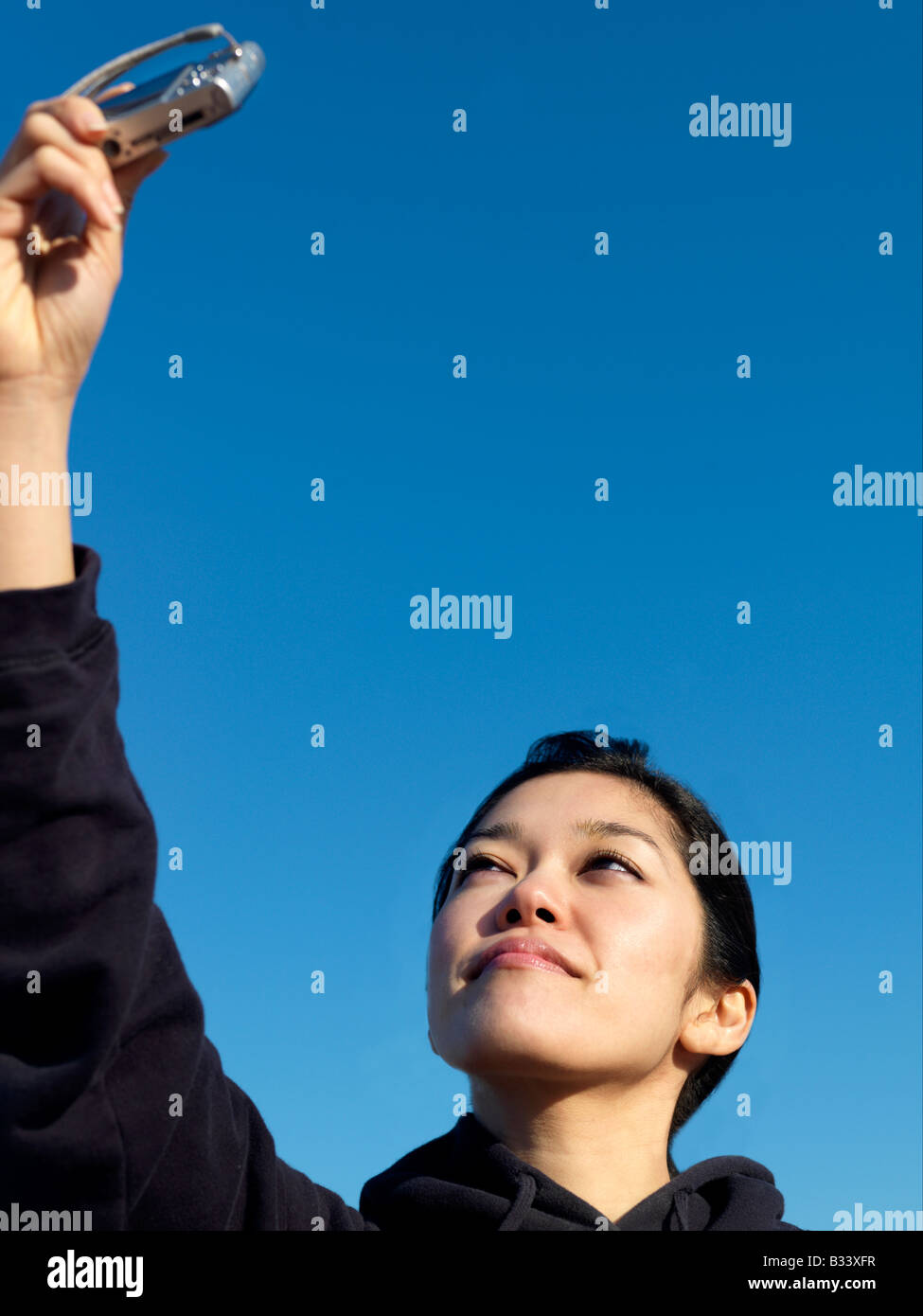 Eine junge asiatische Frau nimmt Selbstporträts mit einem Mobiltelefon Stockfoto