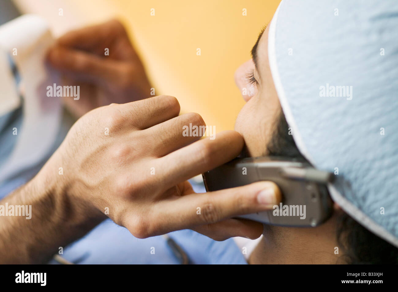 Arzt Untersuchung einer ECG Anzeige während des Gesprächs auf ein Handy Stockfoto