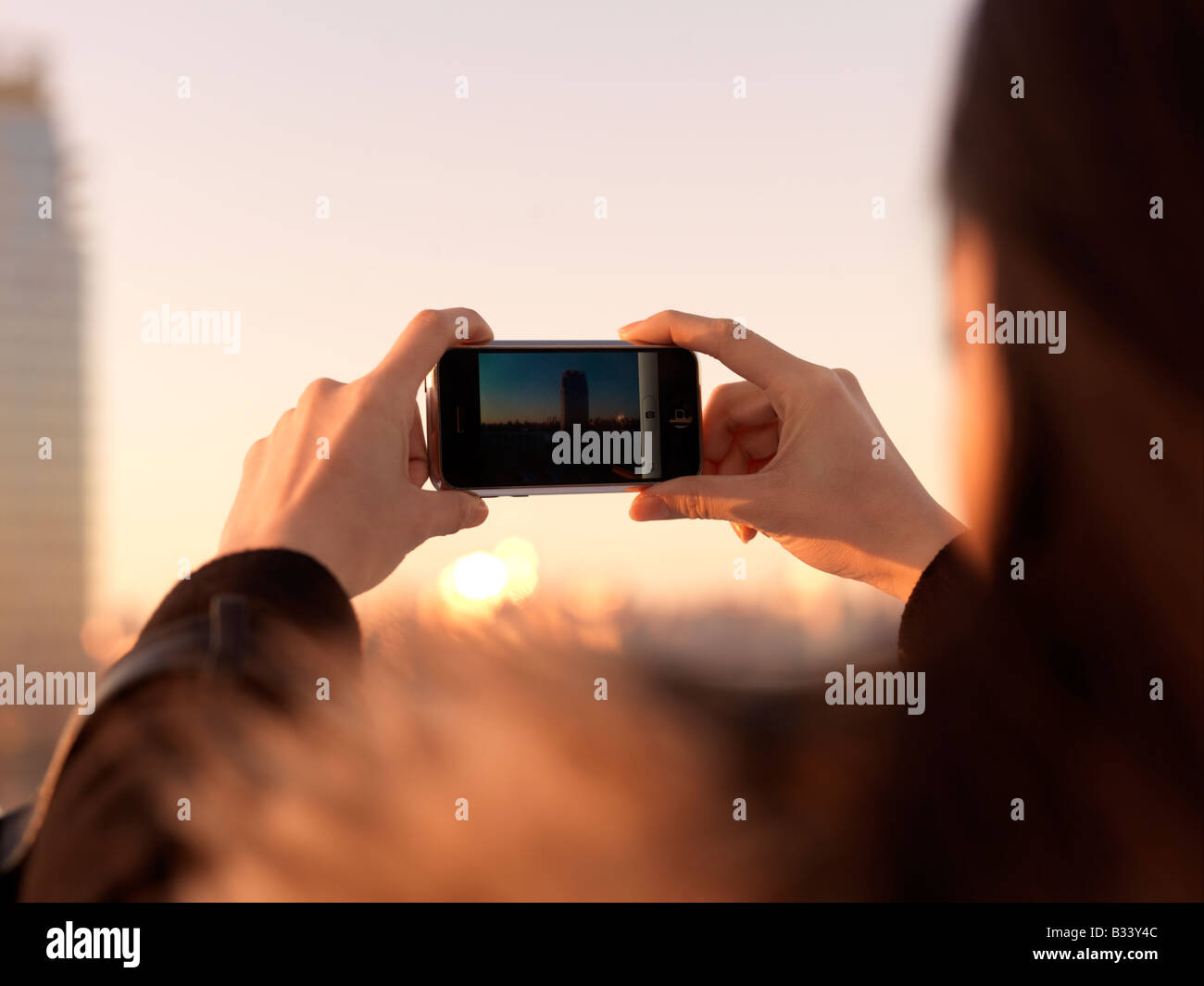 Eine junge Chinesin, die mit ihrem Mobiltelefon um ein Foto aufzunehmen. Stockfoto