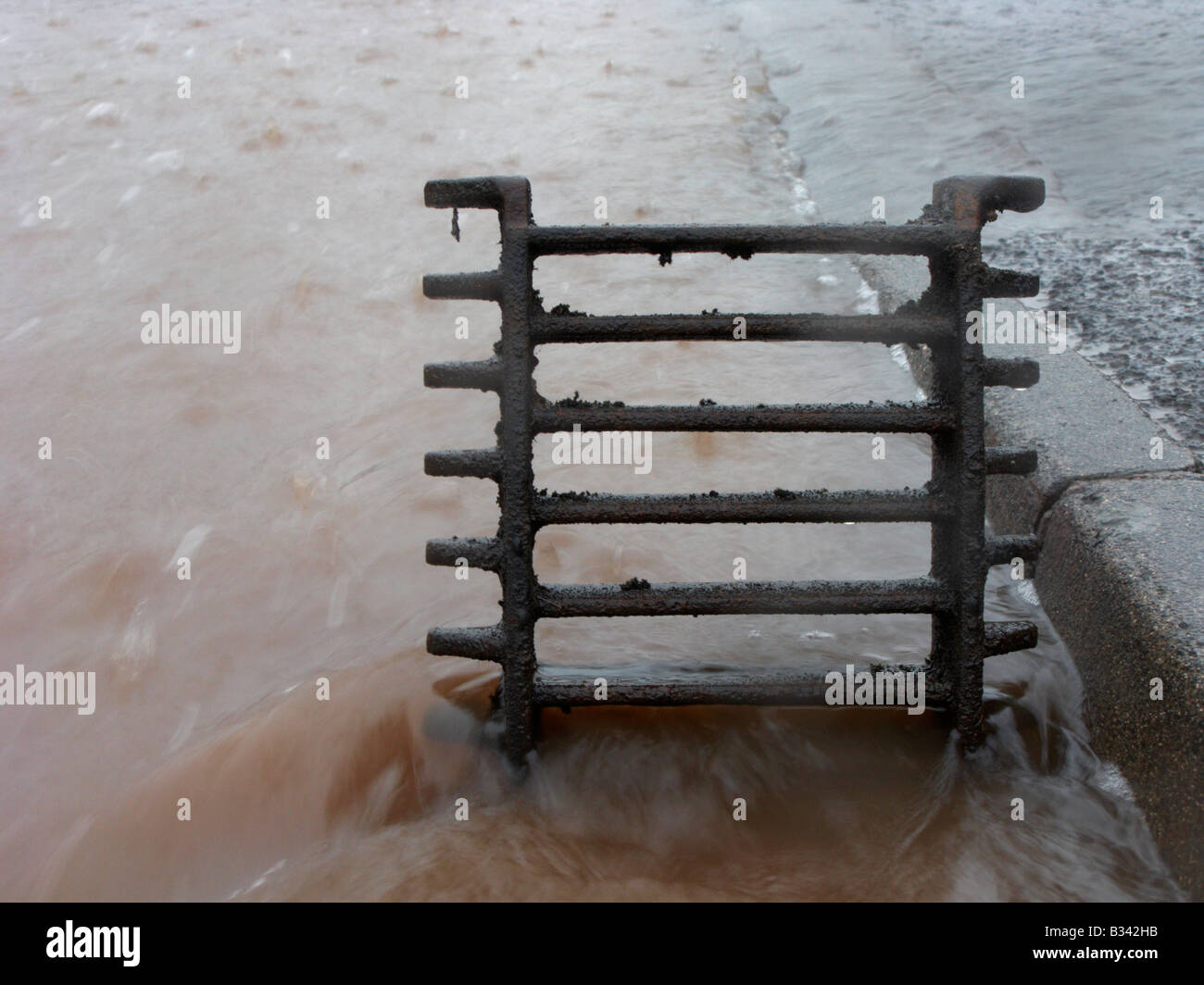 am Straßenrand Abfluss geöffnet, um Regen und Fluss Überlauf Fluten einer Straße im Herzinfarkt Grafschaft Antrim uk abfließen Stockfoto