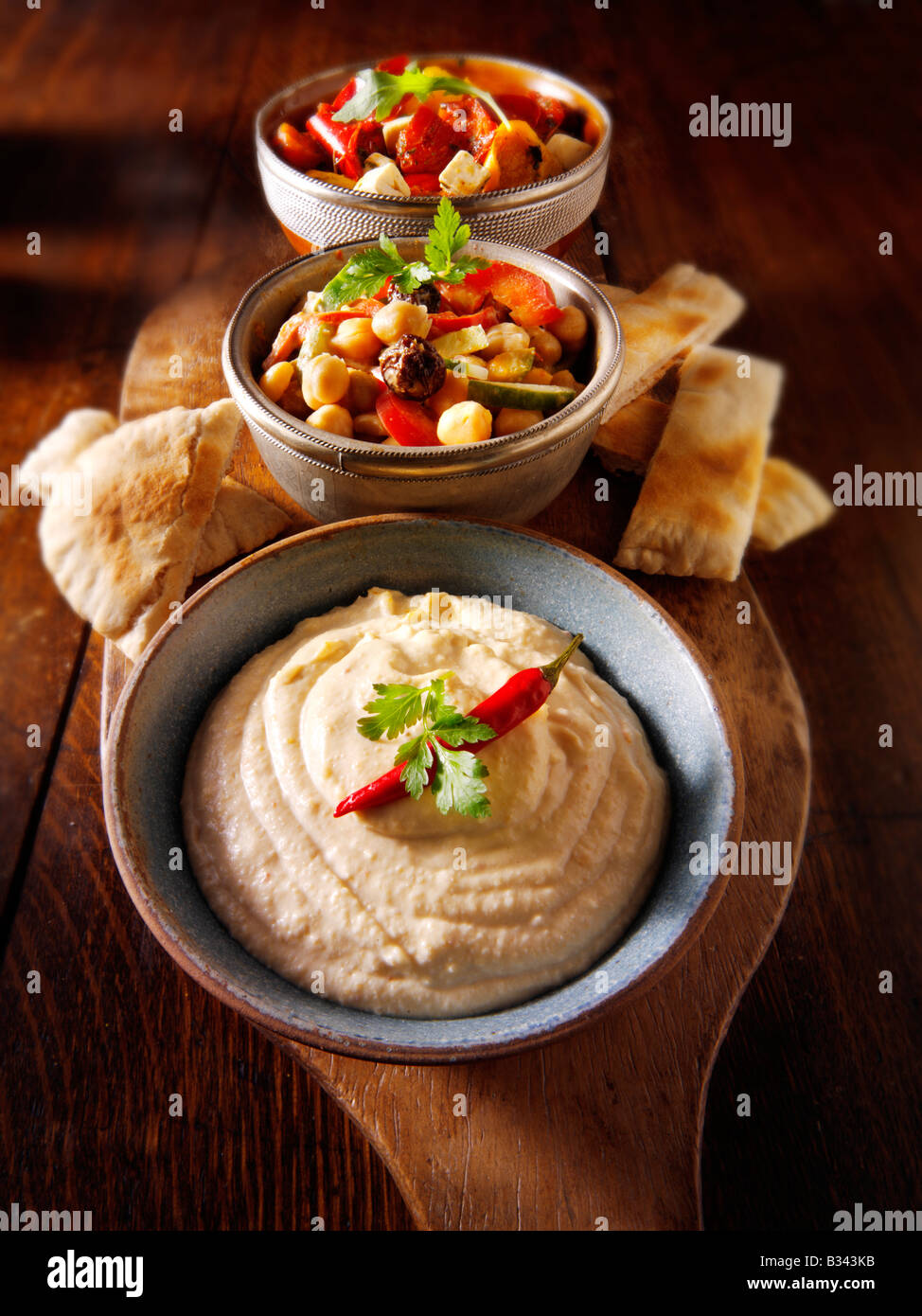 Party Food - von vorne - Houmous, [Kichererbse] Salat, marinierte mediterrane gebratene Paprika Stockfoto