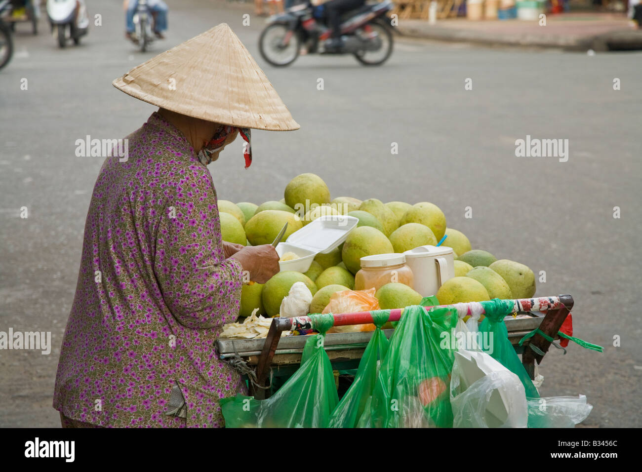 Eine Frau und ihre Frucht stall auf einer Straße in Ho Chi Minh, Vietnam Stockfoto