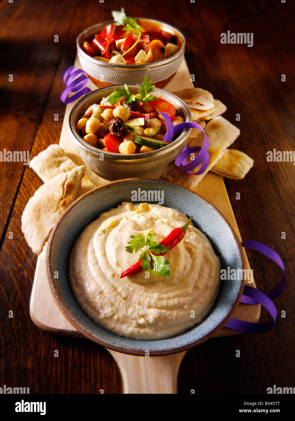 Party Food - von vorne - Houmous, Küken Erbse Salat, marinierte mediterrane gebratene Paprika Stockfoto