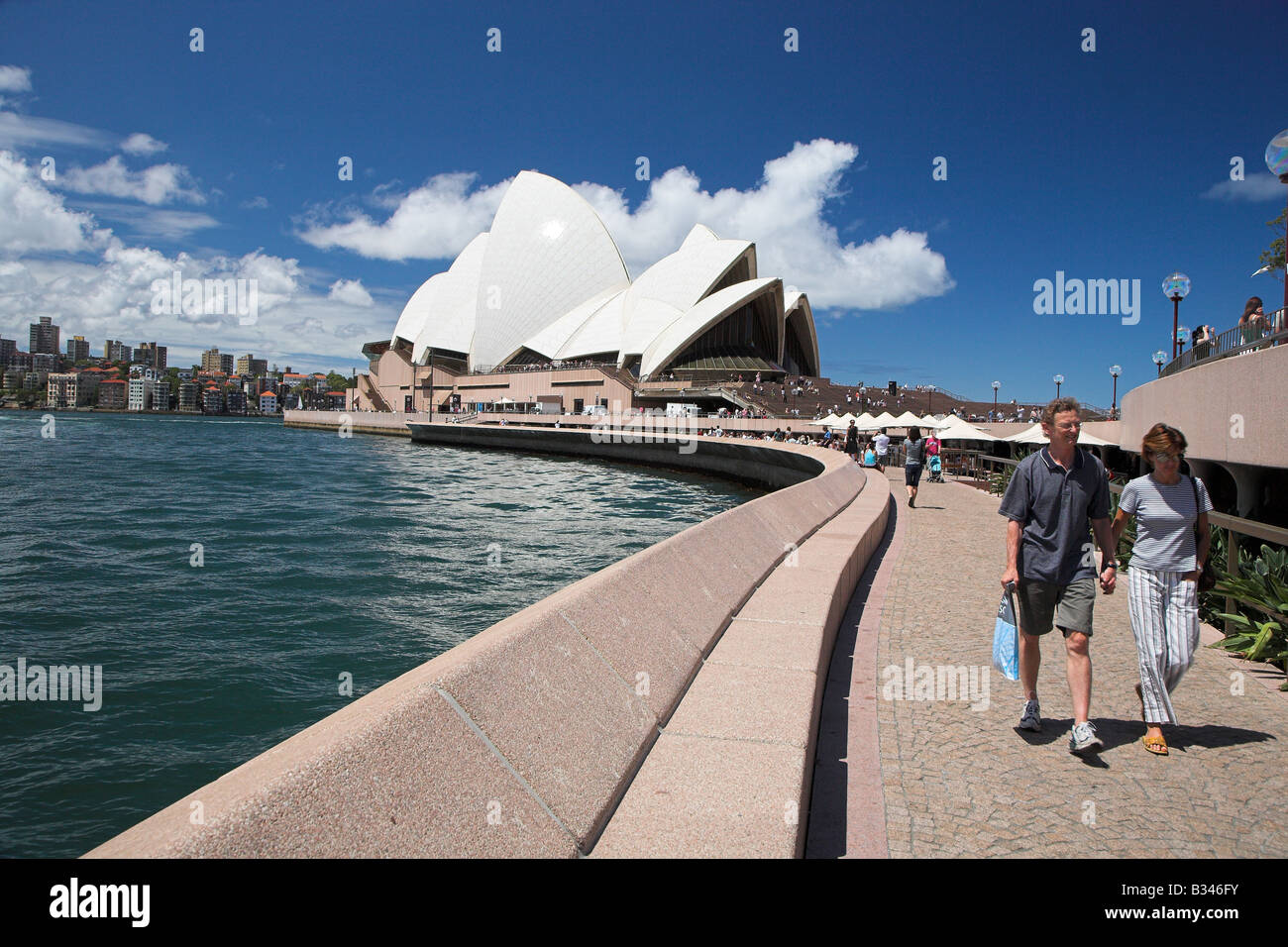 Touristen schlendern vorbei an Sydney Opera House in Sydney, New South Wales in Australien. Stockfoto