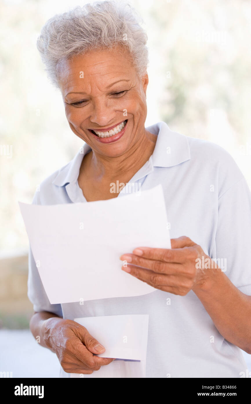 Frau liest Brief lächelnd Stockfoto