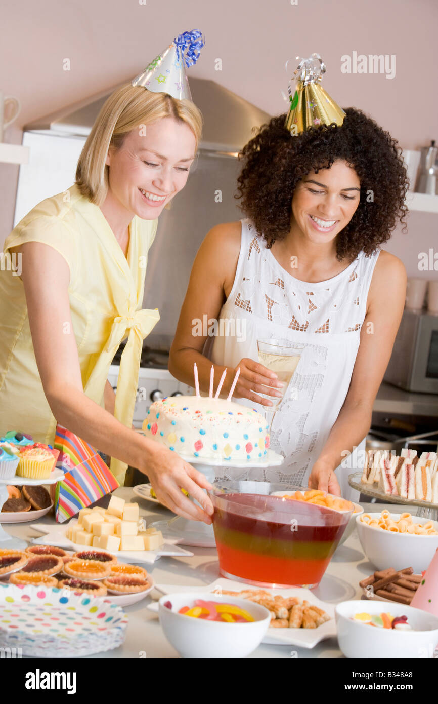 Zwei Frauen an Partykulisse heraus essen Lächeln Stockfoto