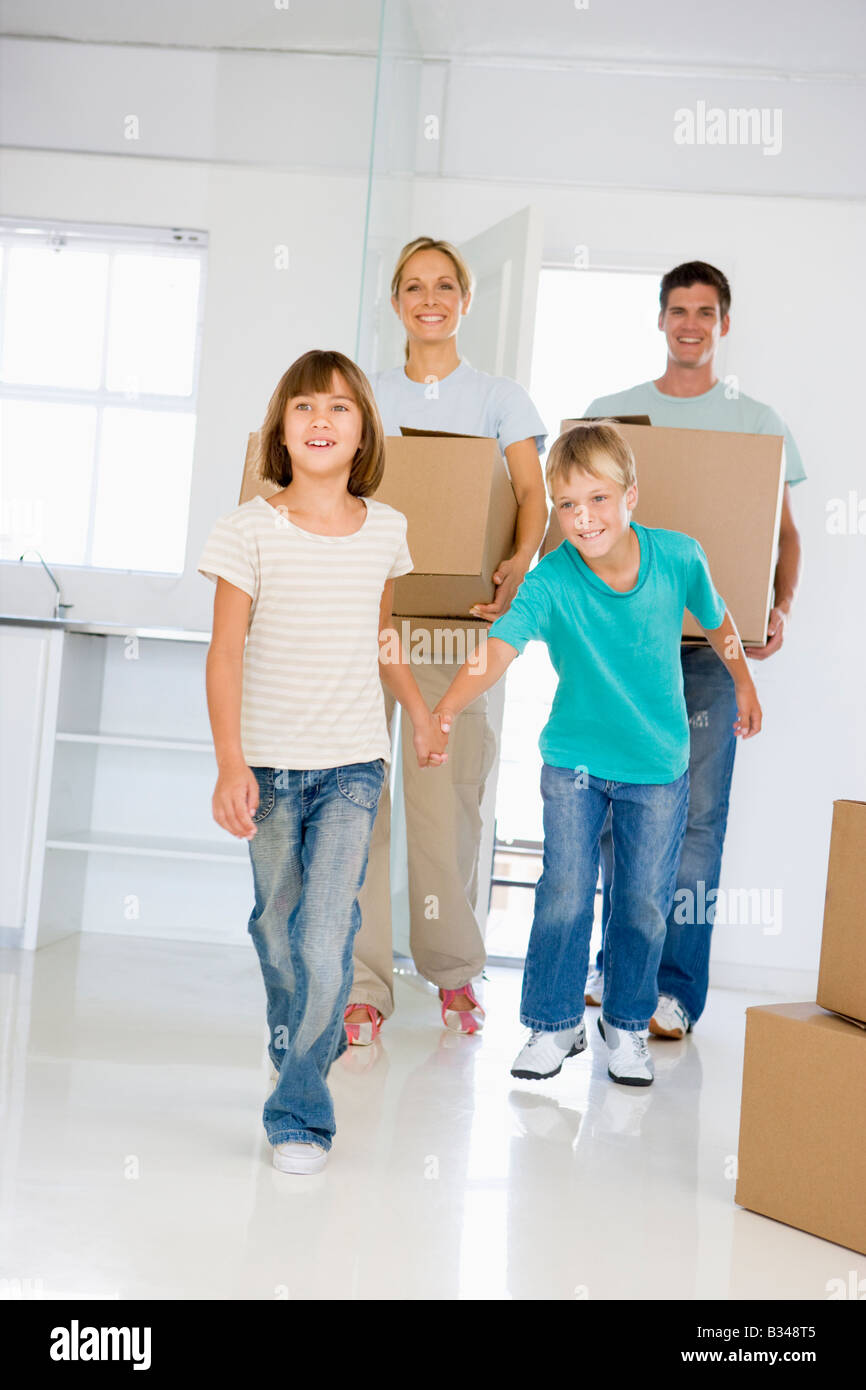 Familie mit Boxen Einzug in die neue Heimat lächelnd Stockfoto
