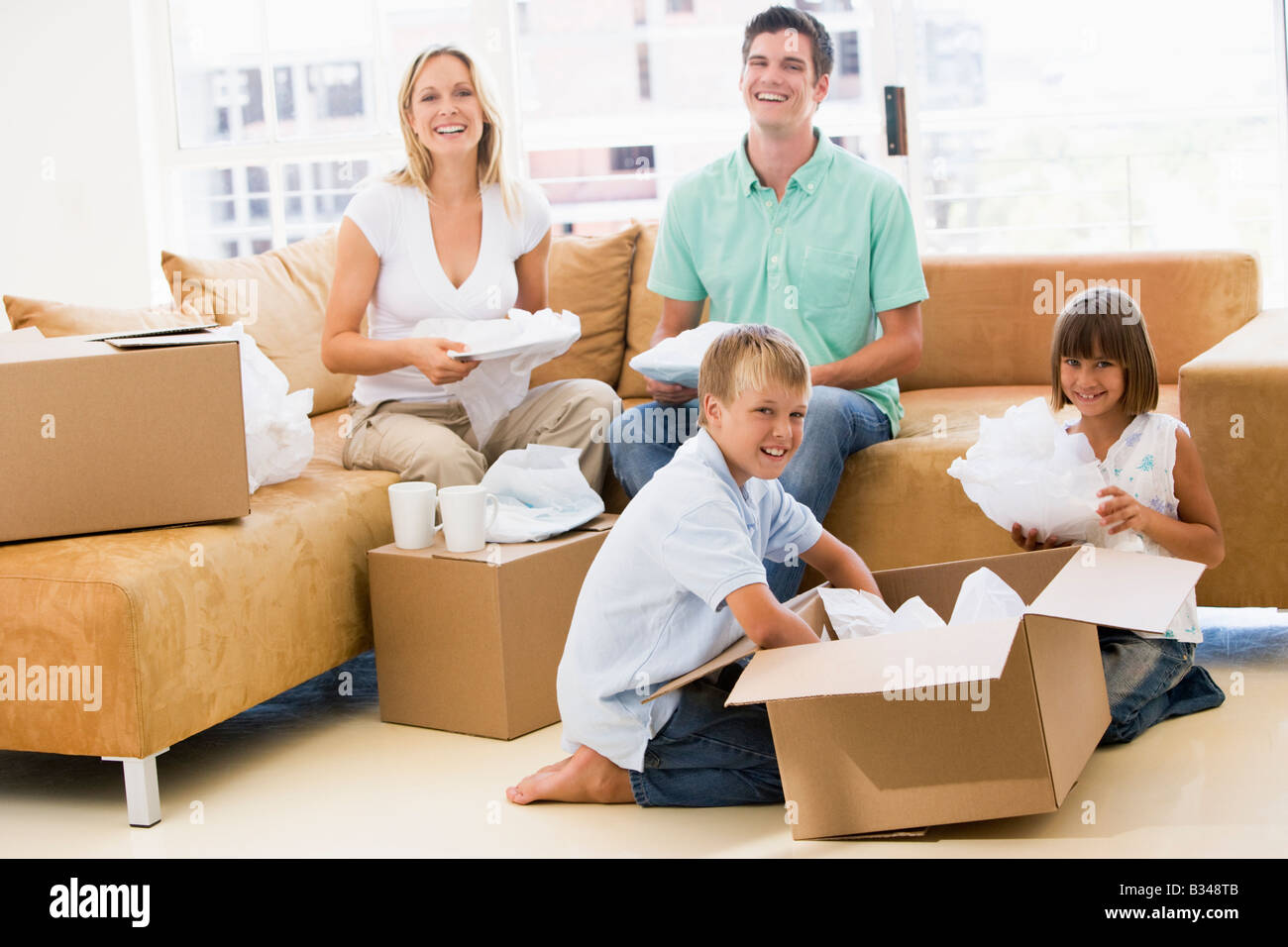 Familie Auspacken Boxen im neuen Hause lächelnd Stockfoto