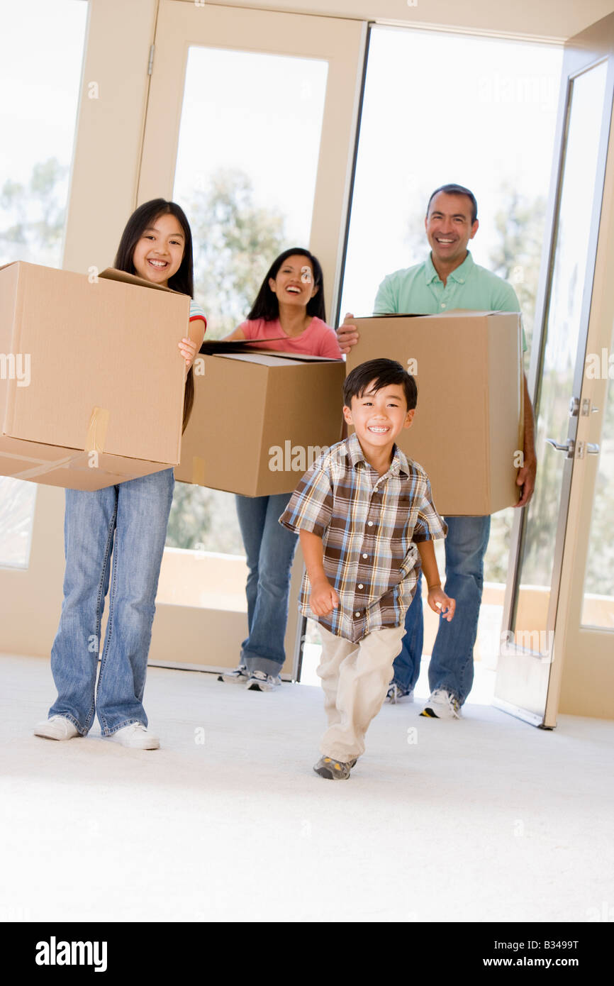 Familie mit Boxen Einzug in die neue Heimat lächelnd Stockfoto