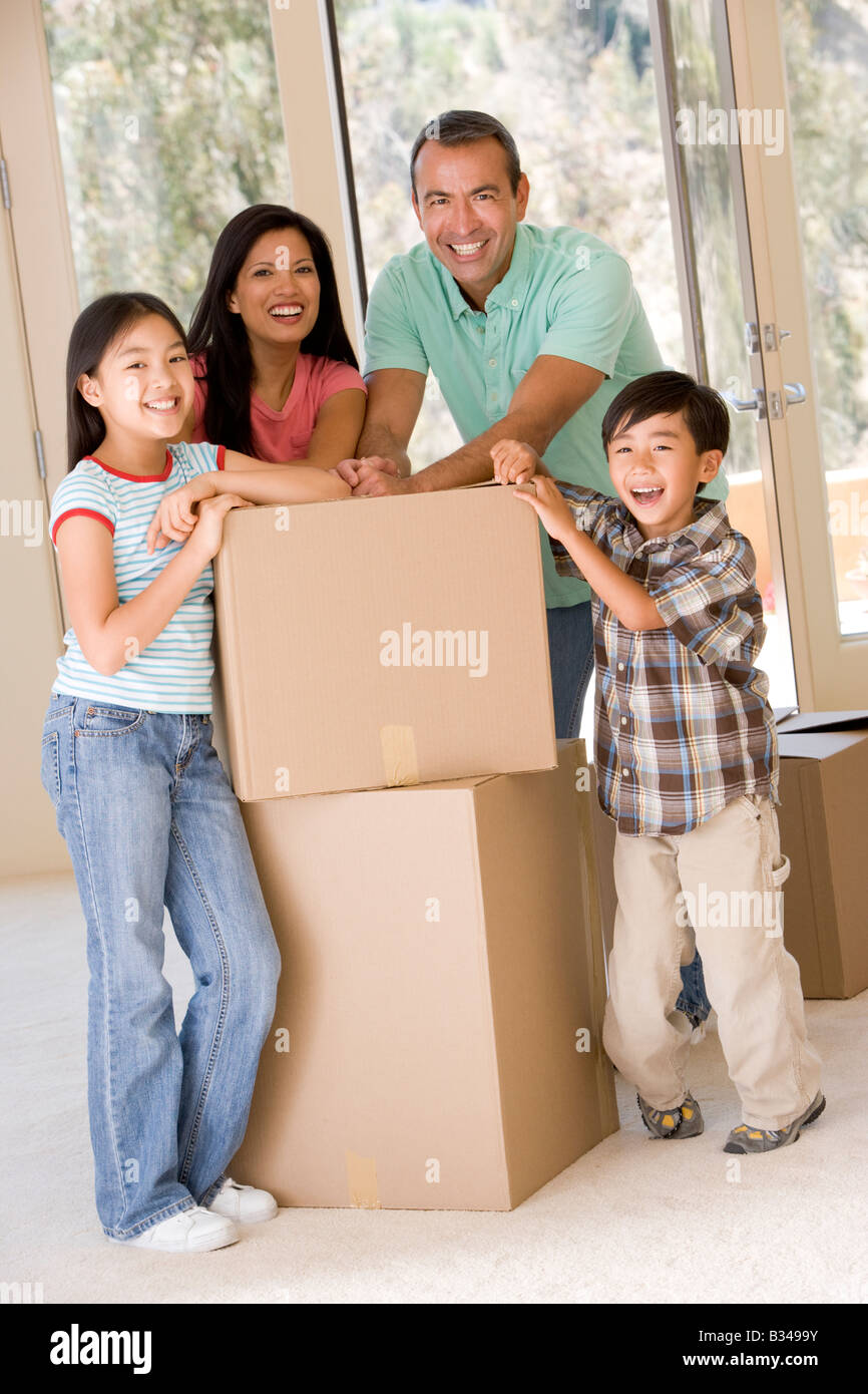 Familie mit Boxen im neuen Hause lächelnd Stockfoto
